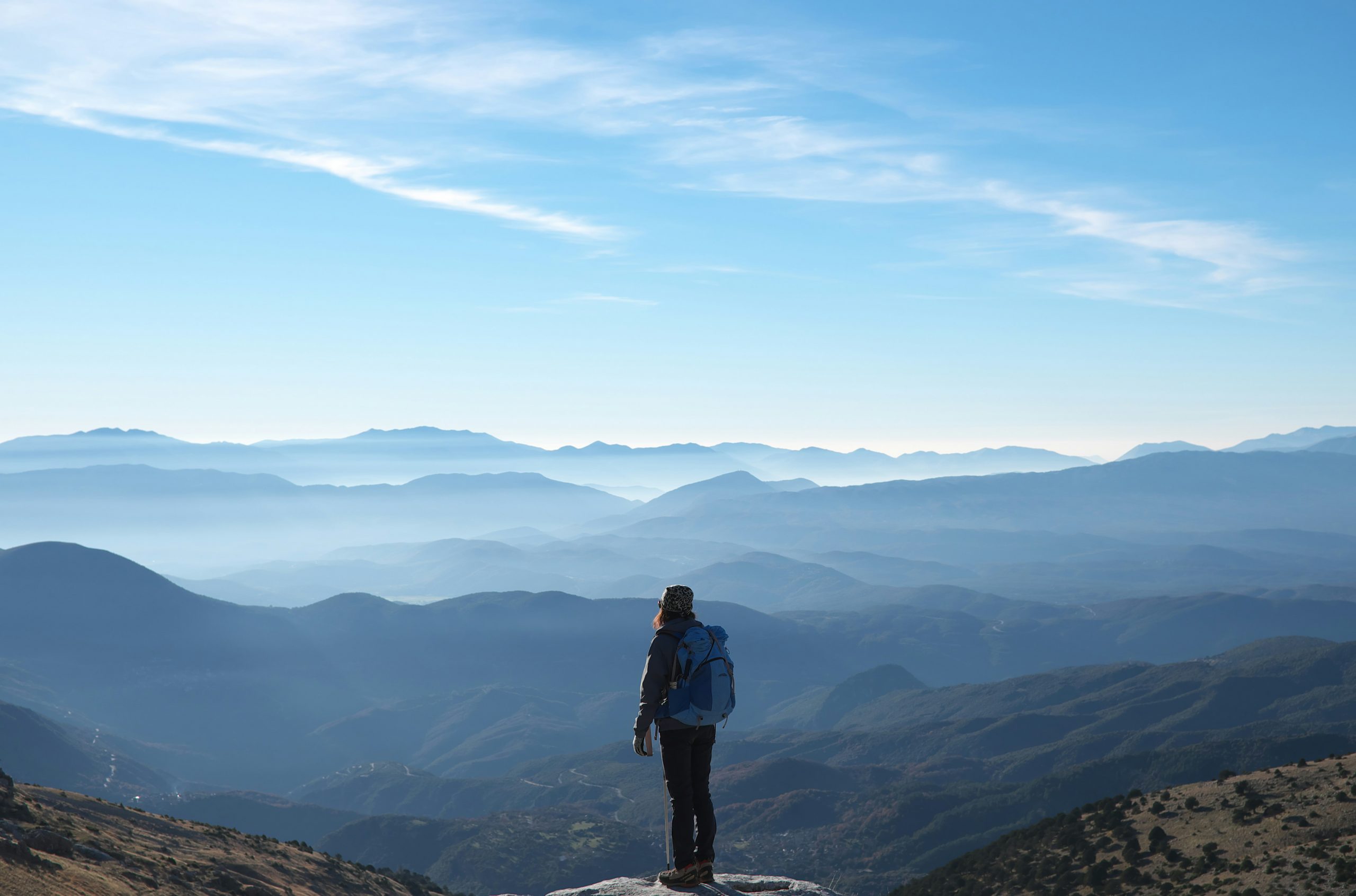 a lady standing on top of a mountain taking in the view